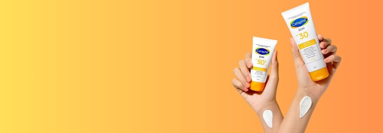 a hand holding a bottle of sunscreen